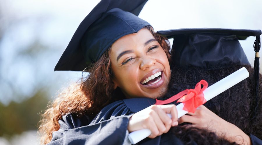 Portrait of a young woman hugging her friend on graduation day